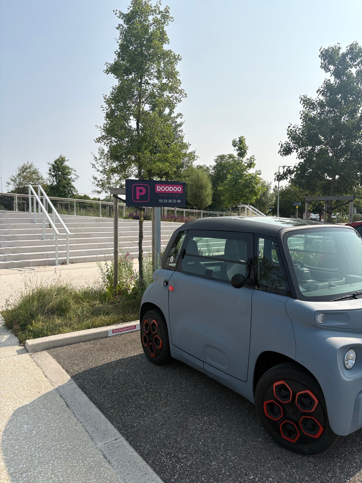 Compact electric rental car on a dedicated DOODOO parking spot